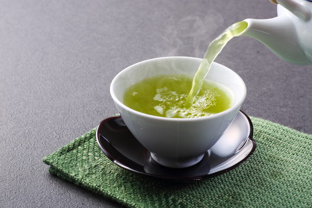 pouring cup of green tea